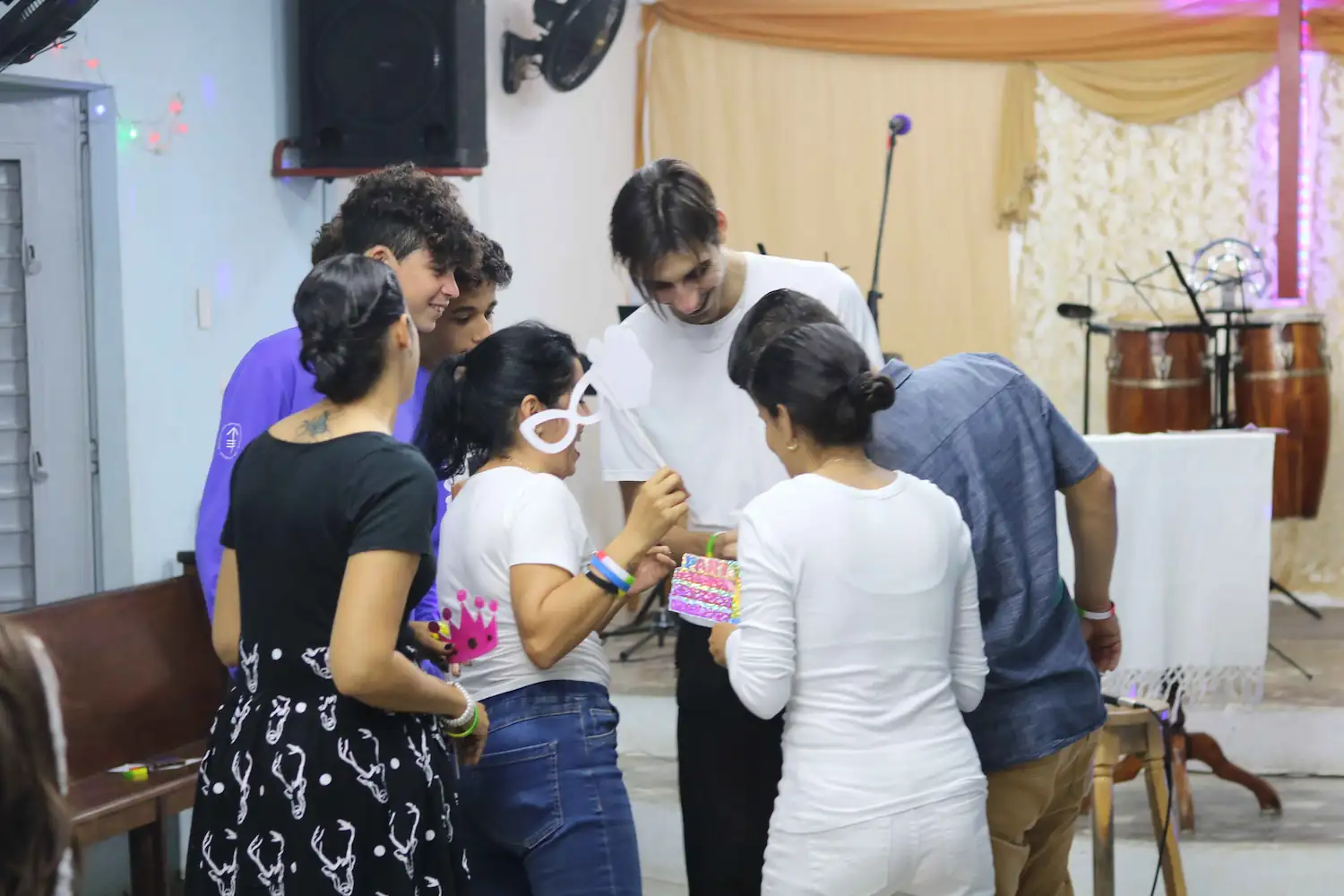 Jóvenes de Calvary Caibarién compartiendo y riendo en el salón después del culto