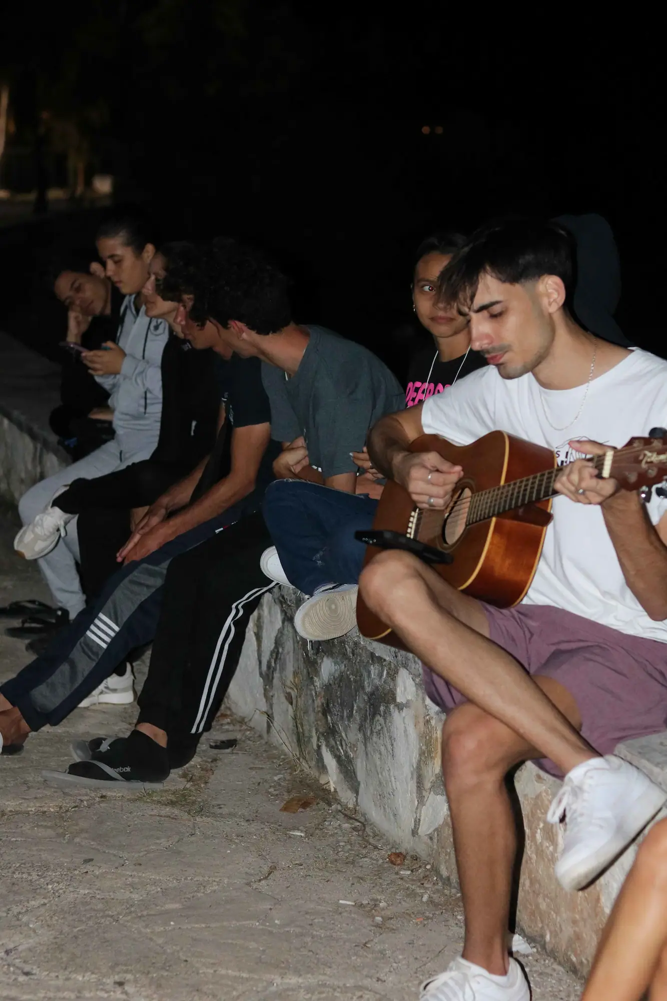 Grupo juvenil adorando con manos en alto en el malecón de Caibarién al atardecer